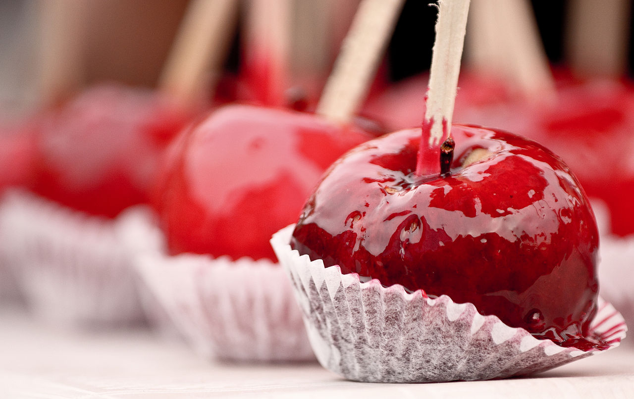 Close-up of red candy apples with wooden sticks